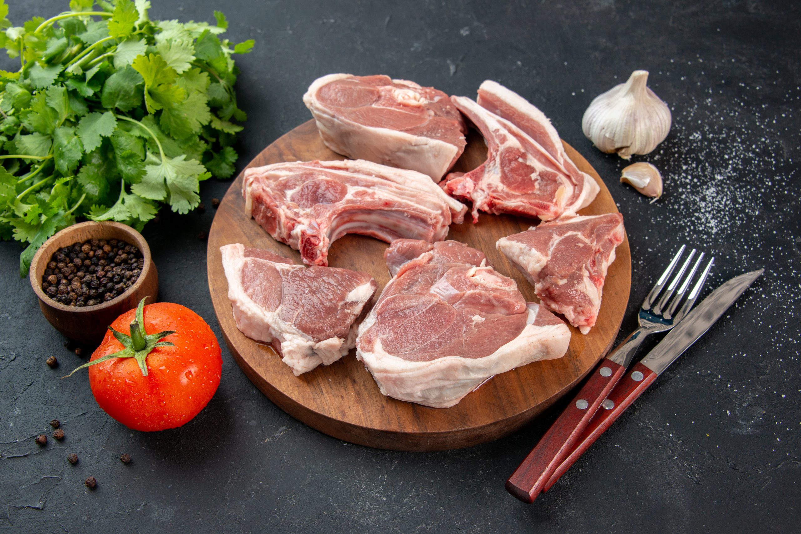 front-view-fresh-meat-slices-raw-meat-with-greens-tomatoes-dark-background-kitchen-meal-food-cow-food-dish-salad-barbecue-animal